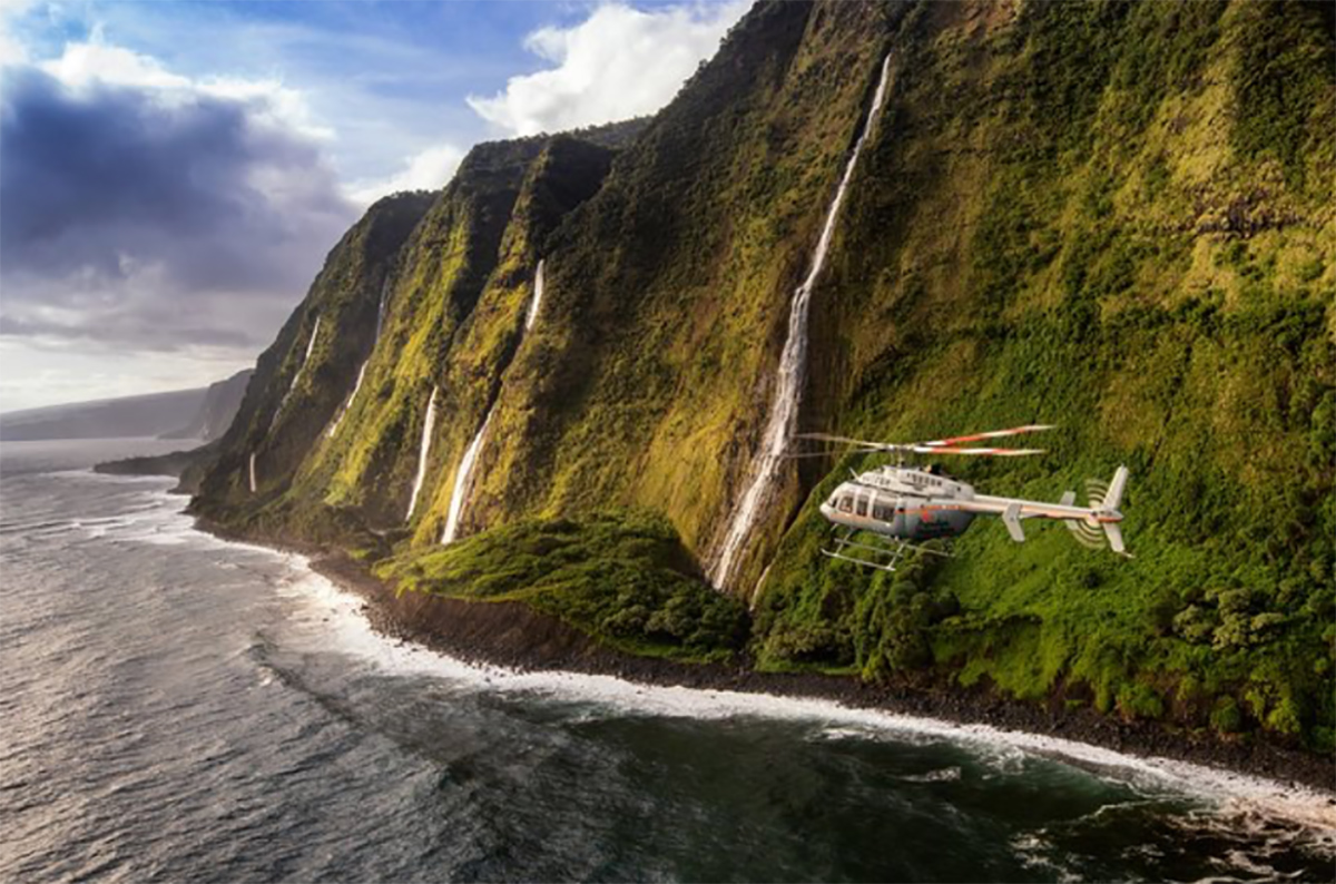 helicopter flying over ocean by island hawaii