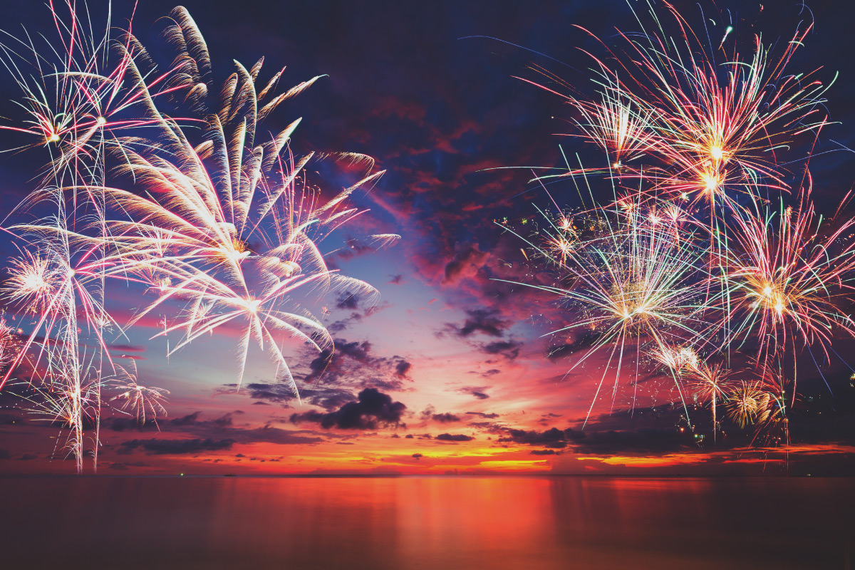 Fireworks over water at sunset